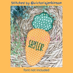 May include: An orange carrot-shaped applique with white polka dots and the name "SAYLER" embroidered in green. A green cloud-shaped applique with white polka dots is above the carrot. The text "Stitched by @victoriajenkins" is at the top.