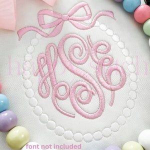 May include: White fabric with a pink embroidered monogram, surrounded by a pearl-like border. A pink bow is at the top. The text "font not included" is at the bottom. Pastel-colored candies are on the left and right.