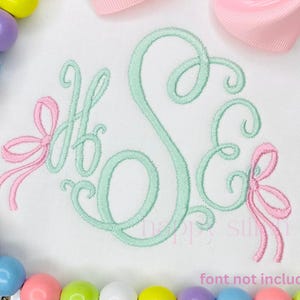 May include: White fabric with a monogram in light green thread, featuring the letters H, S, and E. Pink bows accent the letters. A pink ribbon and a strand of colorful beads are in the background. Text at the bottom reads "font not included."