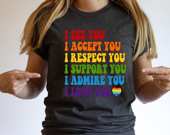 May include: A dark gray t-shirt with the text "I see you, I accept you, I respect you, I support you, I admire you, I love you" in rainbow colors with a rainbow heart at the end.