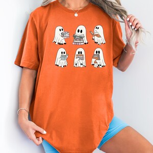a woman wearing a t - shirt with ghost characters on it