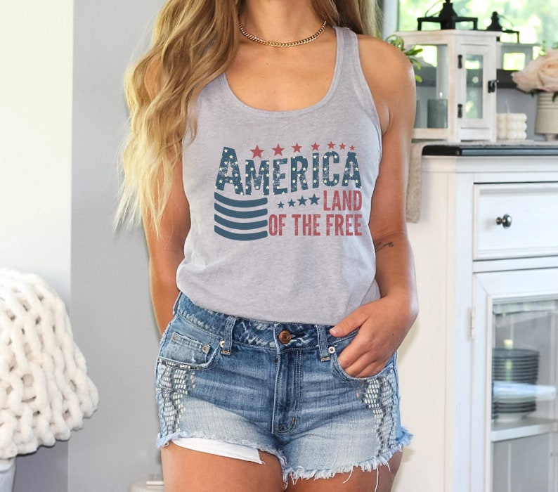 a woman wearing a tank top and denim shorts