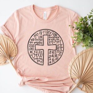 a pink t - shirt with a cross on it