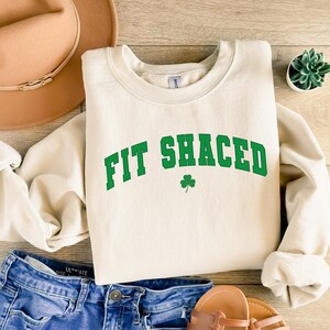 a white sweatshirt that says fit sauced next to a pair of shorts and a