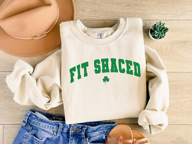 a white sweatshirt that says fit sauced next to a pair of shorts and a