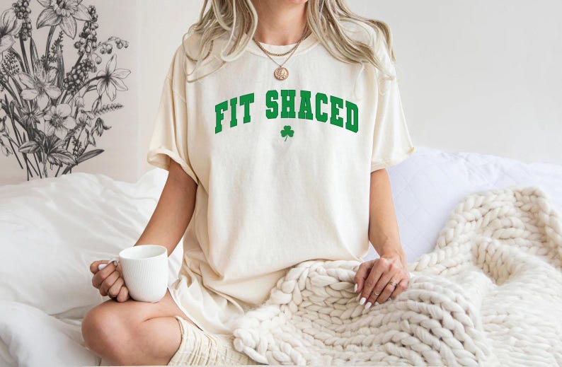 a woman sitting on a bed holding a cup of coffee