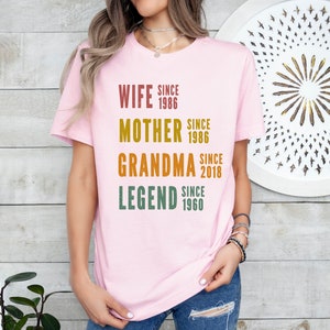 a woman wearing a pink t - shirt with the words, wife since grandma since