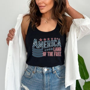 a woman wearing a tank top that says america land of the free