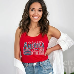 a woman wearing a red tank top with america on it