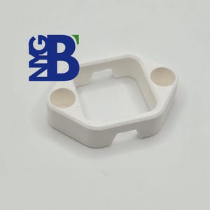 Puede incluir: Objeto cuadrado de plástico blanco con dos agujeros redondos en los lados. El objeto está diseñado para sujetar un objeto pequeño.