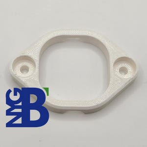 Puede incluir: Pieza de plástico blanco impresa en 3D con dos agujeros. La pieza tiene forma de rectángulo redondeado con una gran abertura en el centro.