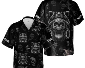 Peut inclure: Chemise noire à boutons avec un motif de crânes répété. La chemise présente un grand motif de crâne au dos avec une couronne et des cornes. Les mots "NAME" et "YOUR" sont imprimés sur la chemise.