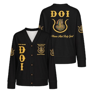 May include: A black V-neck cardigan featuring gold text and Egyptian-inspired graphics. The front displays 'DOI' and 'Your Court #99 Oasis of City Desert of States'. The back features 'DOI', an Egyptian figure, and 'Women Mind Body Spirit'.