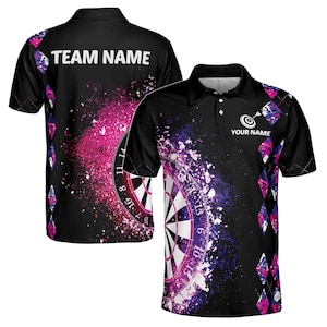 Pode incluir: Camisola polo preta e roxa com tema de dardos com um design de alvo branco e salpicos de tinta rosa e roxa. A camisa tem um colarinho branco e uma aba de botões branca. O texto "TEAM NAME" é impresso na parte de trás da camisa e "YOUR NAME" é impresso na parte da frente da camisa.