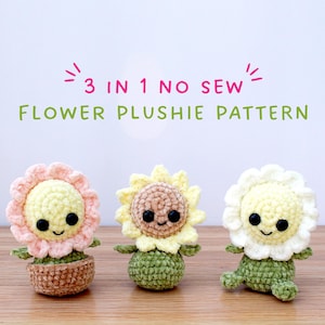 Peut inclure: Trois peluches de fleurs crochetées, chacune avec une fleur de couleur différente et une tige verte. Les peluches sont disposées en rangée sur une surface en bois. Le texte "3 IN 1 NO SEW FLOWER PLUSHIE PATTERN" est affiché au-dessus des peluches.