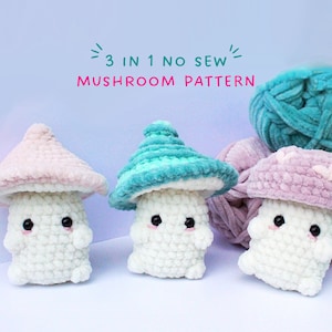 May include: Three crocheted mushroom amigurumi toys in pink, teal, and light pink. The mushrooms are all white with black eyes and a smiling mouth. The text "3 in 1 no sew mushroom pattern" is written above the mushrooms.