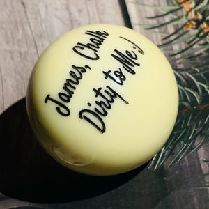 May include: A white billiard ball with black lettering that reads "James Chalk Dirty to Me!"