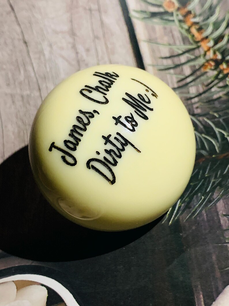 May include: A white billiard ball with black lettering that reads "James Chalk Dirty to Me!"