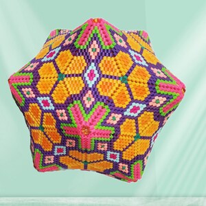 Puede incluir: Un objeto geom&eacute;trico de forma de estrella, colorido, hecho de cuentas de pl&aacute;stico. El objeto es una mezcla vibrante de naranja, rosa, morado, verde y blanco.