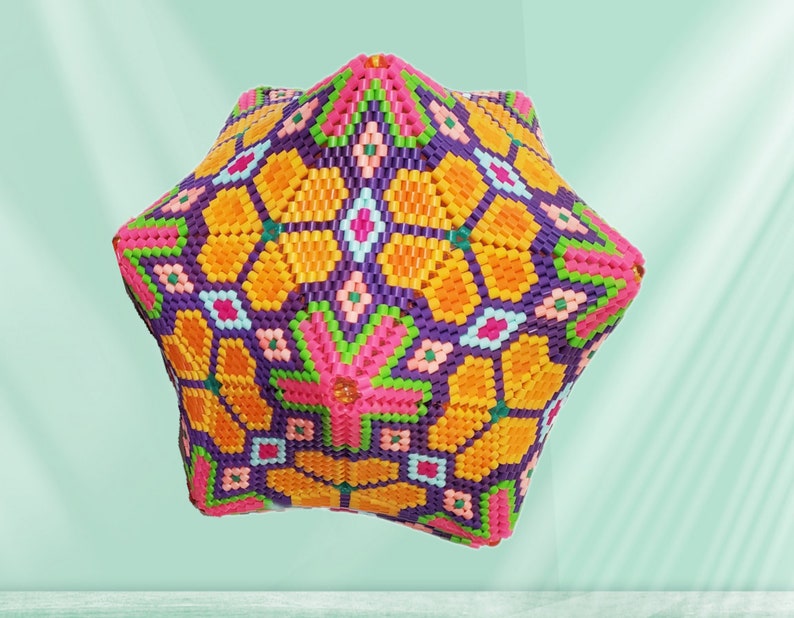 Puede incluir: Un objeto geom&eacute;trico de forma de estrella, colorido, hecho de cuentas de pl&aacute;stico. El objeto es una mezcla vibrante de naranja, rosa, morado, verde y blanco.