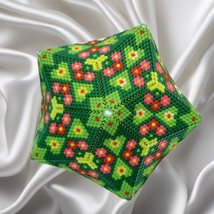 Puede incluir: Un cubo geom&eacute;trico verde, amarillo, rosa y rojo con cuentas con un patr&oacute;n floral. El cubo est&aacute; hecho de peque&ntilde;as cuentas de pl&aacute;stico y tiene un dise&ntilde;o sim&eacute;trico.