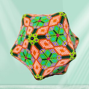 Puede incluir: Una escultura geom&eacute;trica de cuentas multicolores con una base en forma de estrella y un patr&oacute;n complejo y sim&eacute;trico. La escultura est&aacute; hecha de cuentas rosas, naranjas, verdes, azules y moradas.