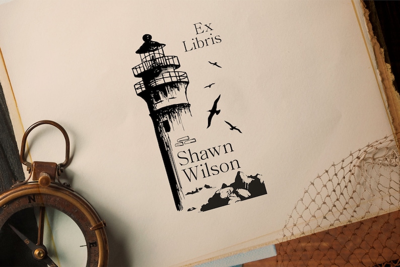 May include: Black and white illustration of a lighthouse with birds flying around it. The text "Ex Libris" and "Shawn Wilson" is below the lighthouse.