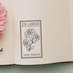 May include: A black and white bookplate with the text "Ex-Libris" and "Jade March" with a floral design of three stylized flowers.