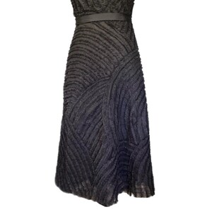 May include: A dark gray dress with a textured, ribbed design. The dress features a fitted bodice, a thin belt at the waist, and a flared skirt. The fabric has a unique, layered appearance.