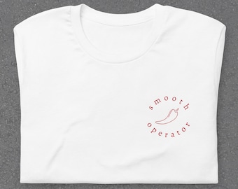 Puede incluir: Camiseta blanca con un contorno rojo de un chile y el texto "smooth operator" en un círculo.