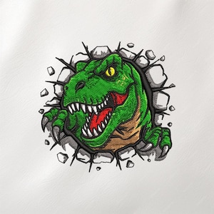 Könnte beinhalten: Gesticktes Design eines grünen Tyrannosaurus Rex, der durch eine zerbrochene Wand bricht. Der Dinosaurier hat scharfe weiße Zähne, einen roten Mund und gelbe Augen. Das Design befindet sich auf weißem Hintergrund.
