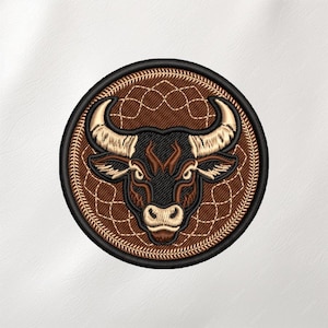 May include: Embroidered patch featuring a bull's head in shades of brown, black, and cream. The bull's head is centered within a circular design with a textured brown background and a black border. The patch is likely for apparel or accessories.