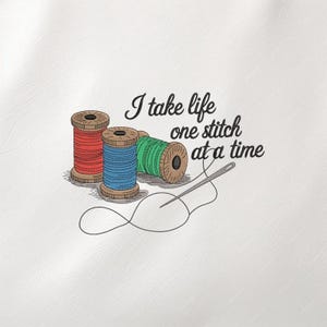 May include: An embroidered design featuring three spools of thread in red, blue, and green, with a needle and thread. The text reads, "I take life one stitch at a time."