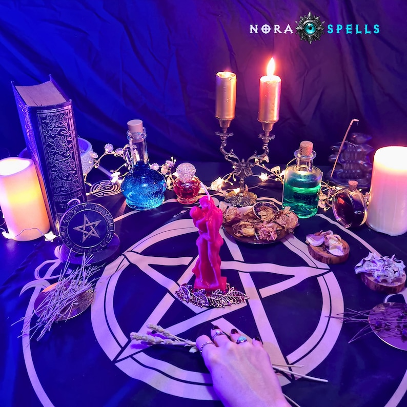 May include: A dark blue altar cloth featuring a white pentagram, topped with a red candle, a gold candelabra with two lit candles, glass bottles containing blue and green liquids, a vintage book, and dried herbs under the text NORA SPELLS.