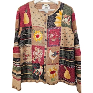 May include: A long-sleeve button-down cardigan featuring a patchwork design with various knit patterns and embroidered motifs including sunflowers, roosters, pears, and baskets of flowers in shades of tan, red, green, and yellow with a Tiara label.