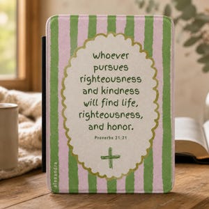 May include: A rectangular e-reader case featuring vertical light pink and green stripes. The centre displays a scalloped cream-coloured oval with the text: whoever pursues righteousness and kindness will find life, righteousness, and honour. Proverbs 21:21.