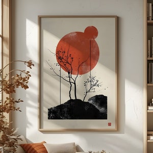 May include: A framed print of a minimalist landscape with a large red circle and two black trees. The print is hanging on a white wall in a room with a wooden bench and pillows.