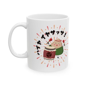 May include: White ceramic mug with a cartoon rice ball playing a drum. The rice ball is wearing a green leaf and has a happy face. The text "ハイヤッサ!" is written in black on the mug.