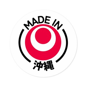 May include: A white circle sticker with black text that reads "Made in" and a red circle with a white ring inside. The text "沖縄" is written in black below the red circle.