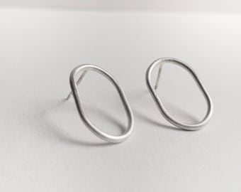 May include: A pair of silver oval-shaped earrings with a brushed finish.