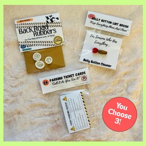 May include: A collection of novelty items, including "Back Road Rubbers," "Belly Button Lint Brush," "Belly Button Cleaner," "Parking Ticket Cards," and a "Your Parking Sucks!" checklist. The image includes the text "You Choose 3!"