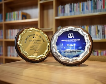 Könnte beinhalten: Zwei runde Plaketten mit goldenen und silbernen Verzierungen. Die Plakette links ist golden mit dem Text "Store Manager of the Year" und "Edmund Tierney". Die Plakette rechts ist silbern mit blauem Hintergrund und dem Text "Certificate of Appreciation" und "Petter".