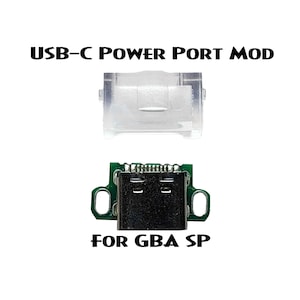 Op de afbeelding: Een USB-C-voedingspoort-mod voor de Game Boy Advance SP. De mod bevat een transparante kunststof behuizing en een groene printplaat met een USB-C-poort.