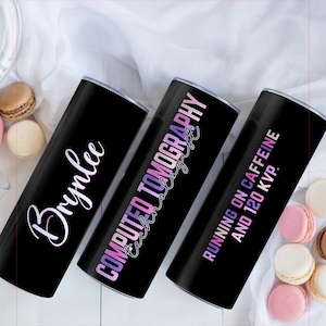 May include: Three black insulated tumblers with white, pink, and purple text. One tumbler says "Brynlee" in cursive, another says "COMPUTED TOMOGRAPHY technologist", and the third says "RUNNING ON CAFFEINE AND 120 KVP."