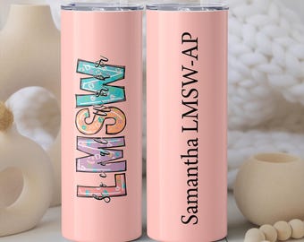 May include: Two pink stainless steel tumblers with a straw. One tumbler has the text "LMSW" in colorful letters with a floral pattern. The other tumbler has the text "Samantha LMSW-AP" in black text.