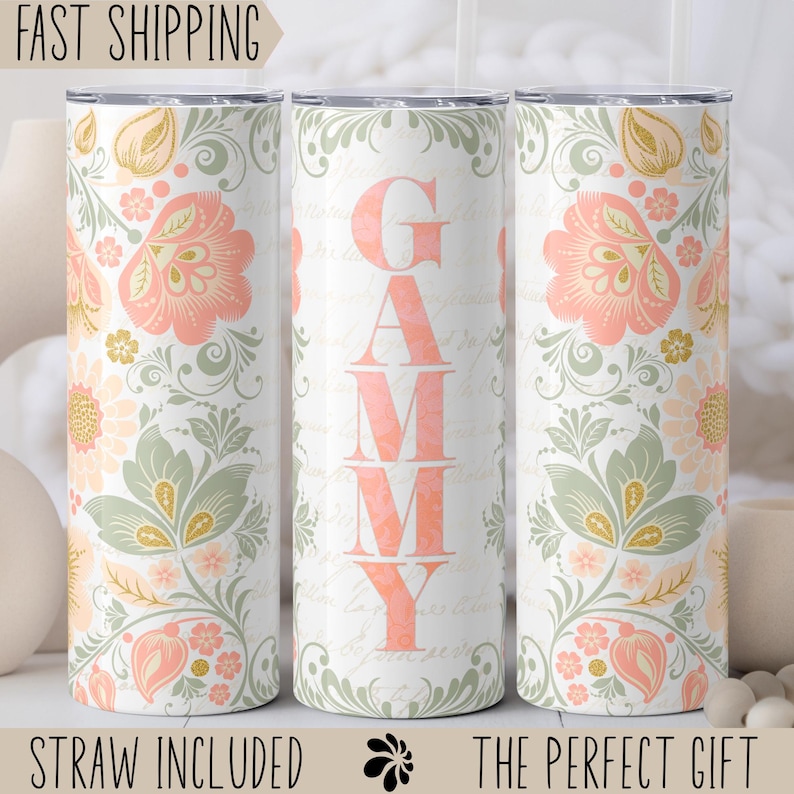May include: Three stainless steel tumblers with a floral pattern and the name "GAMMY" on the middle tumbler. The tumblers are white with pink, green, and gold accents.