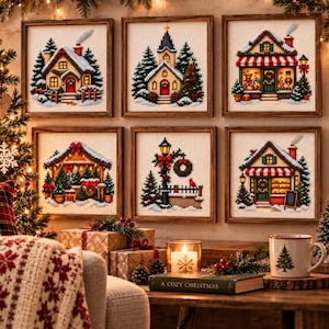 Op de afbeelding: Zes vierkante ingelijste kruissteekkunstwerken met diverse kersttaferelen, waaronder huizen, een kerk en een lantaarnpaal, gerangschikt in twee rijen aan een muur. Elk stuk bevat gedetailleerde wintermotieven met sneeuw, dennenbomen en decoraties.