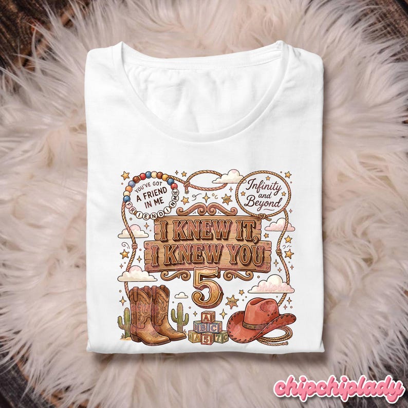 May include: A white t-shirt featuring a graphic print with a cowboy theme. The design includes a pair of brown cowboy boots, a brown cowboy hat, wooden blocks, and text that reads "I KNEW IT, I KNEW YOU 5", "YOU'VE GOT A FRIEND IN ME", and "Infinity and Beyond".