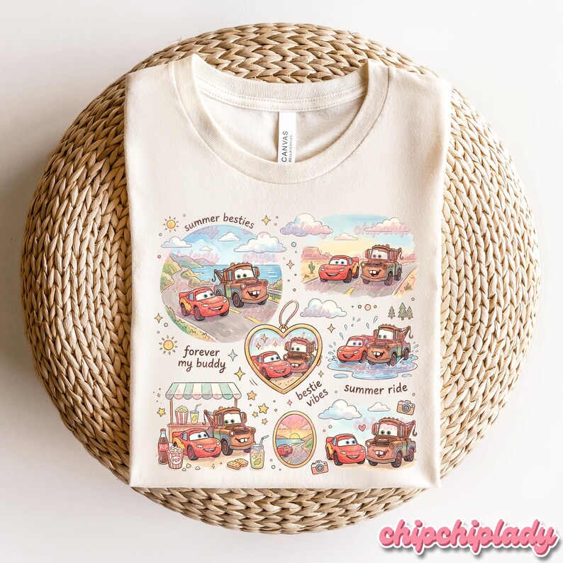 May include: Cream-colored t-shirt featuring a colorful graphic of cartoon cars in various scenes. The design includes text that reads "summer besties," "forever my buddy," and "bestie vibes." The shirt is laid on a woven surface.