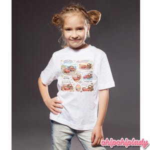 May include: A young girl wearing a white t-shirt featuring a colorful graphic of cartoon cars. The graphic includes text such as "Summer besties" and "Forever my buddy". The shirt is paired with blue jeans.